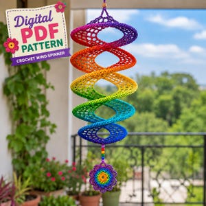 May include: A spiral crochet wind spinner featuring a vibrant rainbow gradient of purple, red, orange, yellow, green, and blue yarn. The hanging decoration includes a small, matching rainbow-colored flower pendant at the bottom with beads.