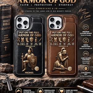 以下が含まれることがあります： PUT ON THE FULL ARMOR OF GODとEphesians 6:10の文字が入った2つのレザー製スマホケース。黒いケースには剣と盾を持つ騎士が描かれMICHAELと記されている。茶色のケースには跪く騎士が描かれEMMAと記されている。