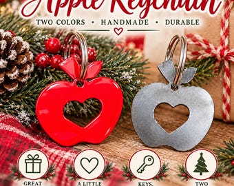 Pode incluir: Dois porta-chaves em forma de maçã com um recorte em forma de coração no centro. Um é vermelho brilhante e o outro é cinzento metálico mate. Cada um possui um anel de metal no topo. O texto diz Apple Keychain, Two Colors, Handmade, Durable.