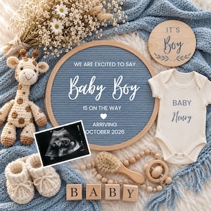 May include: A blue felt letter board with the text WE ARE EXCITED TO SAY Baby Boy IS ON THE WAY ARRIVING OCTOBER 2026, a cream bodysuit with the text BABY Henry, a crochet giraffe, baby booties, a wooden disc saying IT'S Boy, and an ultrasound.