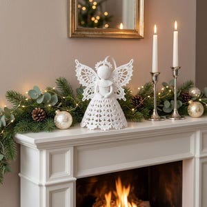 May include: A white crocheted angel figurine featuring intricate lace-like wings and a textured dress, positioned centrally. The angel has a round head with a halo and is crafted with detailed needlework, showcasing a delicate and symmetrical design.