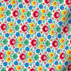 Puede incluir: Una tela blanca con un patrón repetitivo de flores de colores. Las flores son rojas, amarillas, azules, verdes y rosas. El patrón es simétrico y tiene un estilo tradicional de arte popular.