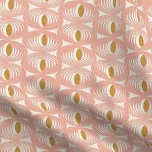 May include: A pink and gold fabric with a repeating pattern of stylized ovals. The ovals are filled with a white and gold concentric circle design.