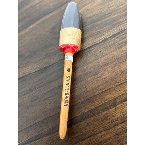 Può includere: Un pennello per stencil con manico in legno chiaro, ghiera in metallo rosso e setole scure. Sul manico è stampata verticalmente la scritta nera "4 STENCIL-BRUSH". La punta del pennello è protetta da un rivestimento in plastica trasparente.