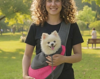 Puede incluir: Un transportín para mascotas de malla gris y rosa brillante con un cierre de cordón en la parte superior. El transportín está diseñado para llevarse al hombro y contiene un perro pequeño de pelaje blanco y esponjoso que asoma la cabeza.
