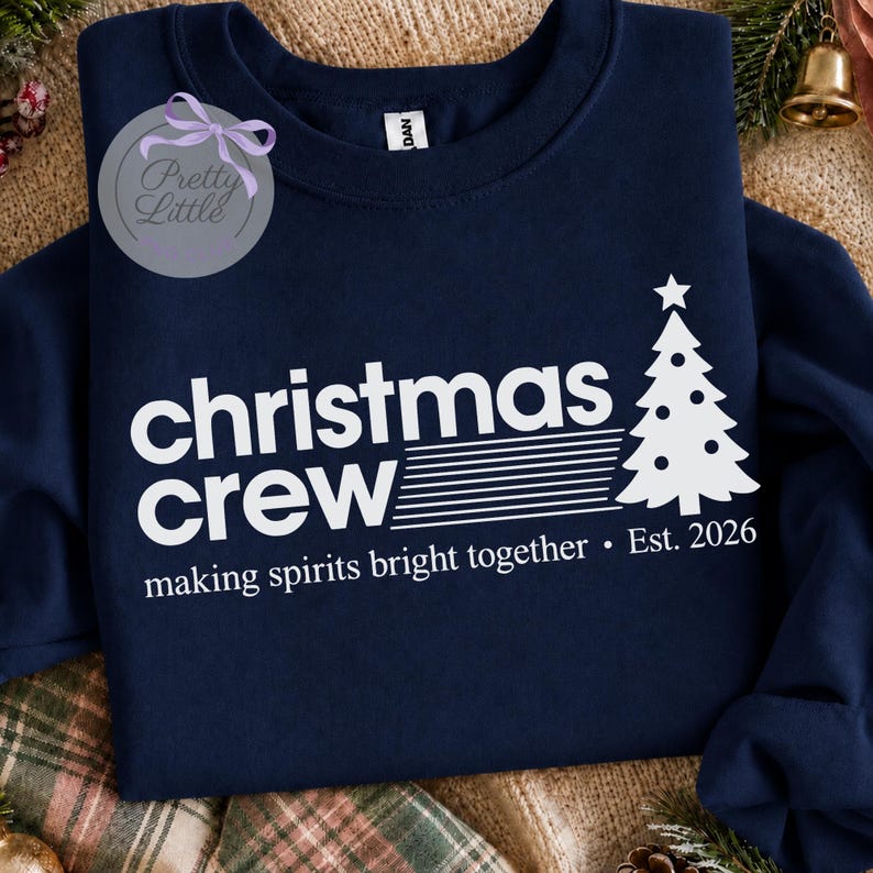 May include: A navy blue crewneck sweatshirt featuring white screen-printed text that reads "christmas crew" with a stylized Christmas tree graphic. Below the text, it says "making spirits bright together &bull; Est. 2026" in white lettering.