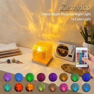 Op de afbeelding: Een vierkant waterrimpel-projector nachtlampje met een getextureerde gele glazen kubus op een houten voet, vergezeld van een afstandsbediening met 16 kleuropties. Het apparaat projecteert een warm, golvend lichtpatroon op de muur.