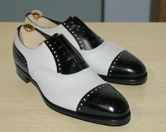 Scarpa Oxford Brogue da uomo in pelle bicolore bianca e nera, realizzata a mano, con punta a coda di rondine. Scarpa da uomo con cucitura Goodyear.