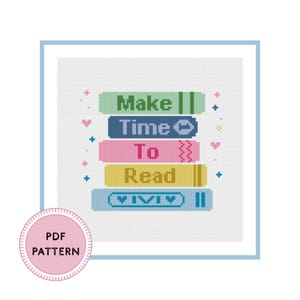 May include: A cross-stitch pattern featuring a stack of five colorful books with the text Make Time To Read. The books are green, dark blue, pink, yellow, and light blue, decorated with small hearts and plus signs on a white grid background.