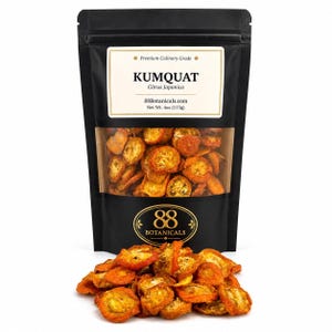 May include: A black stand-up pouch containing dried kumquat slices, labeled Premium Culinary Grade KUMQUAT Citrus Japonica 88Botanicals.com Net Wt. 4oz (113g). A pile of the same dried orange fruit slices is positioned in front of the pouch.