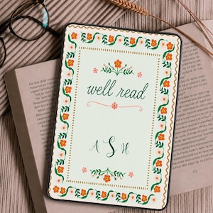 Peut inclure: Une housse de liseuse rectangulaire au fond crème avec une bordure décorative de vignes vertes et de fleurs orange. Le texte "well read" est imprimé en écriture verte au-dessus des initiales "A S H" dans une police cursive verte assortie.