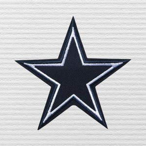 May include: A five-pointed star patch featuring a dark navy blue center with a thin white border and a dark navy blue outer edge. The embroidery has a visible diagonal thread texture throughout the design, creating a clean and defined shape.