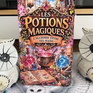 May include: A rectangular card featuring the title LES POTIONS MAGIQUES L'ALCHIMIE ENTRE TES MAINS in gold lettering. The illustration depicts a cauldron, glowing pink and blue potion bottles, an open book with botanical drawings, and a lizard.
