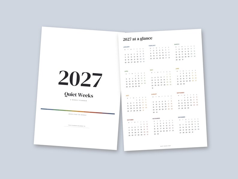 May include: A 2027 Quiet Weeks weekly planner with a white cover featuring the year in large black text and a colorful horizontal line. The open page displays a 2027 at a glance calendar with all twelve months organized in a grid.