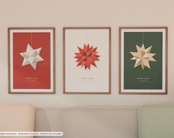 May include: Three framed vertical posters featuring geometric paper star illustrations. The left poster is red with a white star, the centre is cream with a red star, and the right is dark green with a beige star. Each includes the text PAPER STAR.