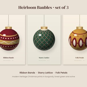 May include: A set of three Heirloom Baubles Christmas ornaments. The first is burgundy with gold ribbon bands, the second is forest green with a gold starry lattice, and the third is ochre with burgundy folk petals. Each features a gold cap.