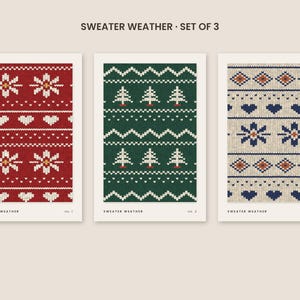 Puede incluir: Un conjunto de tres l&aacute;minas decorativas rectangulares tituladas SWEATER WEATHER. Cada impresi&oacute;n muestra un patr&oacute;n de punto diferente: rojo con copos de nieve y corazones blancos, verde con pinos blancos y beige con copos de nieve y corazones azules.