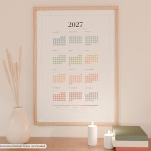 May include: A 2027 wall calendar print featuring a dot-grid layout for each month in a gradient of muted colors. The calendar is displayed in a light wood frame and includes the text 2027 at the top with month names listed below.