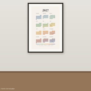 May include: A 2027 wall calendar print featuring twelve monthly grids represented by colorful circular dots arranged in rows. The design includes the year 2027 at the top, month names, and a color-coded legend at the bottom on a light background.