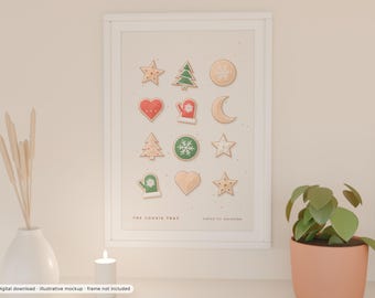 May include: A white framed wall art print featuring a grid of twelve illustrated holiday cookies including stars, trees, hearts, a mitten, and a crescent moon. The text THE COOKIE TRAY and baked for december is printed at the bottom.