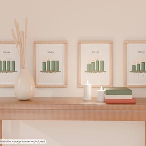 Könnte beinhalten: Vier gerahmte Wandbilder mit Illustrationen von Adventskerzen und dem Text Advent. Die Bilder hängen über einem Holztisch mit einer weißen Vase, getrockneten Stielen, zwei weißen Stumpenkerzen und einem Stapel aus drei Büchern.