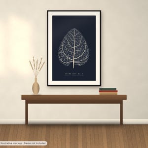 May include: A framed wall art print featuring a white skeletal leaf illustration on a dark navy blue background. The text "BROWN LEAF No. 2" is printed in white at the bottom center of the artwork. The print is displayed in a black frame.