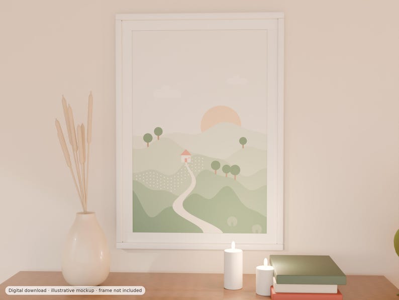 May include: A framed wall art print featuring a landscape illustration of rolling green hills, a winding path, a small house with a pink roof, and a pale orange sun. The artwork is displayed in a white frame on a surface with a vase of dried reeds.