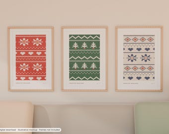 May include: Three framed vertical art prints featuring knit-style patterns. The left print is red with white snowflakes and hearts. The centre print is green with white pine trees. The right print is beige with dark blue hearts and snowflakes. Each print includes the text "SWEATER WEATHER" at the bottom.