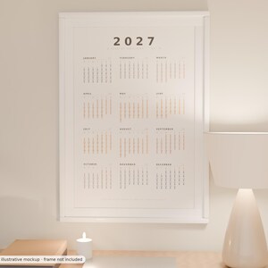 Puede incluir: Un calendario de pared vertical para el a&ntilde;o 2027 en un marco blanco. El calendario presenta un dise&ntilde;o limpio con el a&ntilde;o 2027 en la parte superior, seguido de doce cuadr&iacute;culas mensuales dispuestas en columnas, mostrando las fechas en texto negro y claro.