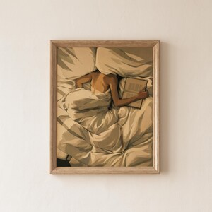 Könnte beinhalten: Ein gerahmter Kunstdruck, der eine Person zeigt, die in einem Bett unter zerknitterten weißen Laken liegt und ein offenes Buch liest. Die Illustration verwendet warme Beige- und Cremetöne, um die Falten der Bettwäsche hervorzuheben.