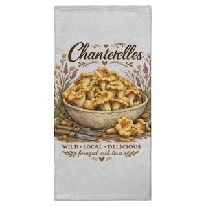 Peut inclure: Un torchon rectangulaire blanc orné d'une illustration centrale de champignons chanterelles dorés dans un bol, deux petits couteaux et des motifs floraux. Le texte indique : Chanterelles, WILD LOCAL DELICIOUS, et foraged with love.