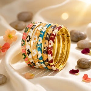 Peut inclure: Un ensemble de six bracelets joncs en métal doré, chacun orné d'un motif floral en émail distinct dans des tons rose, blanc, orange, bleu, noir et rouge. Les bracelets sont disposés en rangée, révélant une finition intérieure polie.