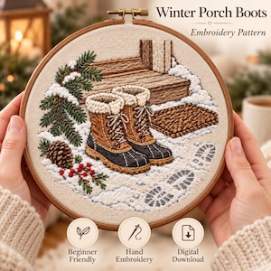 Pode incluir: Um bastidor de bordado com um padrão Winter Porch Boots. O design mostra duas botas de inverno castanhas e pretas num alpendre com neve, com um ramo de pinheiro, uma pinha, bagas vermelhas e um capacho. Texto: Winter Porch Boots Embroidery Pattern.