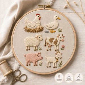 Op de afbeelding: Een ronde houten borduurring met een beige stoffen paneel met handgeborduurde boerderijdieren, waaronder een witte kip op een nest, een eend, een schaap, een bruin-witte koe, een roze varken en een geit met een bel, plus drie ronde iconen.
