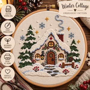Puede incluir: Un bastidor de bordado circular de madera que contiene un panel de tela con una escena de cabaña de invierno bordada a mano. El diseño presenta una casa cubierta de nieve con puerta marrón, dos pinos verdes, copos azules y estrellas amarillas.