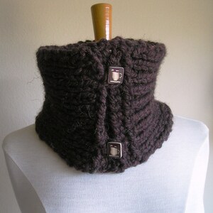 May include: A brown knitted neck warmer with two coffee cup buttons.