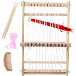 May include: A wooden weaving loom frame with white warp threads, a wooden shuttle holding red yarn, a separate wooden shuttle, a bundle of pink yarn, and a small wooden weaving comb. The loom features metal wing nuts at the four corners.