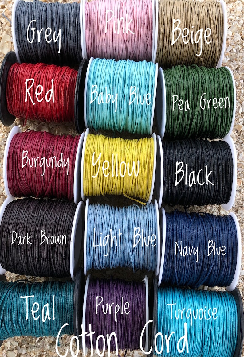 May include: A variety of colorful cotton cord spools are displayed, including grey, pink, beige, red, baby blue, pea green, burgundy, yellow, black, dark brown, light blue, navy blue, teal, purple, and turquoise. The text "Cotton Cord" is also visible.