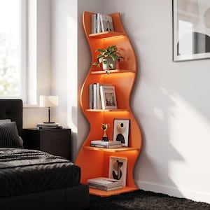 Op de afbeelding: Een hoge, oranje hoekboekenplank met een golvend, organisch silhouet en vijf planken. Elke plank is verlicht door geïntegreerde ledverlichting. De kast bevat diverse boeken, een groene plant, een gouden trofee en ingelijste kunstwerken.