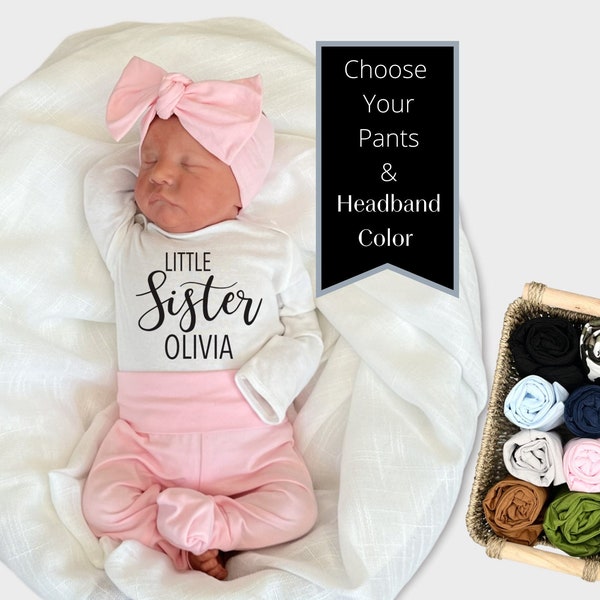 Könnte beinhalten: Ein weißer Strampler mit dem Text "Little Sister Olivia" in Schwarz. Der Strampler wird mit einer rosa Hose und einem rosa Stirnband kombiniert. Das Bild zeigt eine Vielzahl von Farben für die Hose und das Stirnband.