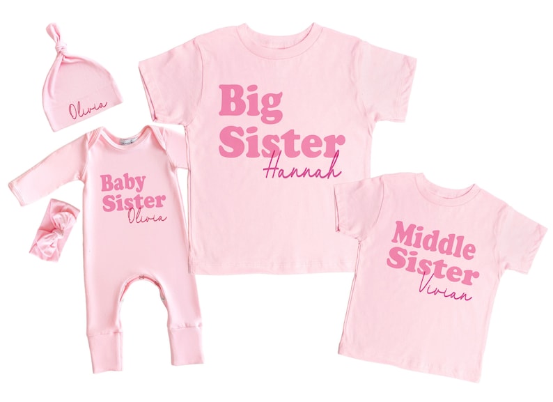 May include: Pink baby onesie with the text "Baby Sister Olivia" in pink, a pink headband, a pink hat with the text "Olivia" in pink, a pink t-shirt with the text "Big Sister Hannah" in pink, and a pink t-shirt with the text "Middle Sister Vivian" in pink.