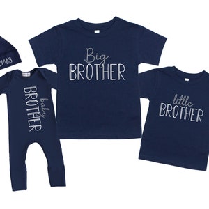 May include: A set of three navy blue clothing items for siblings. A long-sleeved baby onesie with the text "baby brother" in white, a t-shirt with the text "big brother" in white, and a t-shirt with the text "little brother" in white.