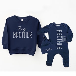 May include: A navy blue sweatshirt with the text "Big Brother" in white. A navy blue baby onesie with the text "little brother" in white. A navy blue hat with the name "Henry" in white.
