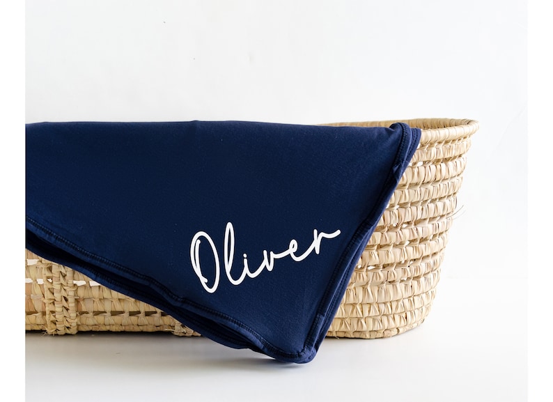May include: A navy blue baby blanket with the name "Oliver" embroidered in white.