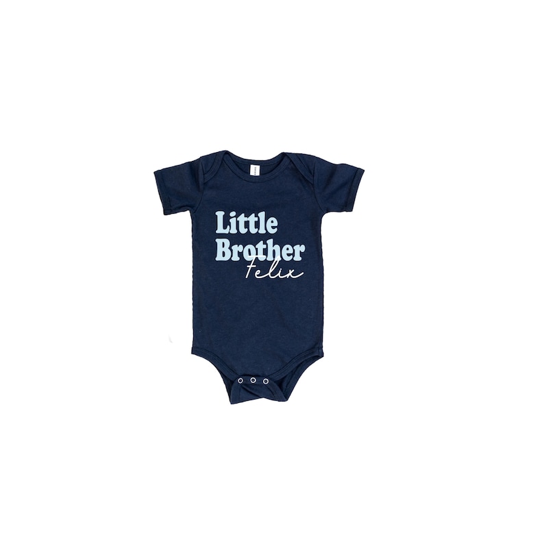 May include: A navy blue baby onesie with the text "Little Brother Felix" in light blue and white.