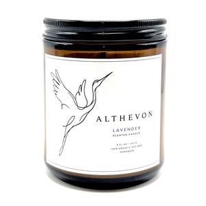 May include: An amber glass jar candle with a black screw-top lid and a white label. The label features a black line drawing of a crane in flight, the text ALTHEVON, LAVENDER SCENTED CANDLE, 8 FL OZ - 227 G, 100% ORGANIC SOY WAX, and HANDMADE.