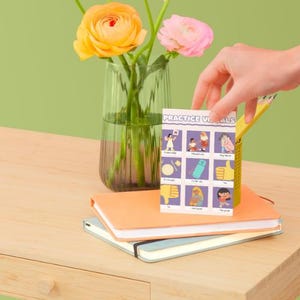 May include: A rectangular card titled Practice Visuals featuring a grid of nine illustrations depicting various social cues and actions, including a thumbs up, a thumbs down, and people interacting, printed on a white background with purple borders.