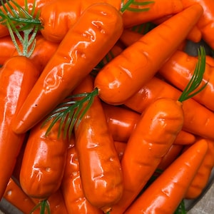 May include: A close-up of a pile of orange carrots. The carrots are arranged in a random pattern and are all about the same size.