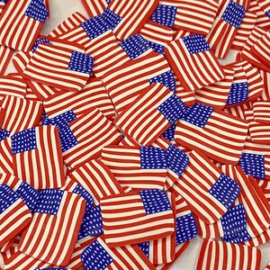 May include: A large pile of small, red, white, and blue American flag-themed embellishments. The flags are made of a thin, flexible material and are perfect for adding a patriotic touch to crafts and decorations.