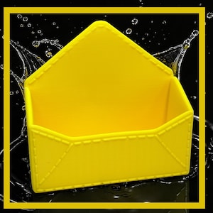 May include: A bright yellow, open-top container shaped like an envelope. The container has a stitched design around the edges and is set against a black background with water droplets. The image is framed with a yellow border.